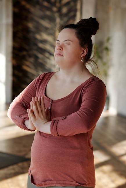 Woman meditating peacefully in a brightly lit room with her eyes closed